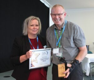 Paul Jenkins collects his Unsung Community Hero award from Vanessa Biddiss, Southern Housing